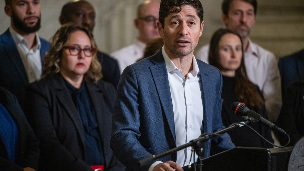 Jacob Frey speaks at a podium in front of other people.