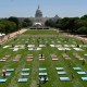 Pink, blue, and white quilt panels rest on the grass of the National Mall.