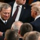 President Trump, right, pats Chief Justice Roberts arm ina crowd of people.