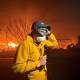 MS NOW's Jacob Soboroff stands with a microphone, wearing a face mask as Palisades fire continues in the background.