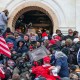 A police office sprays tear gas on a crowd of pro-Trump supporters attempting to enter the Capitol.