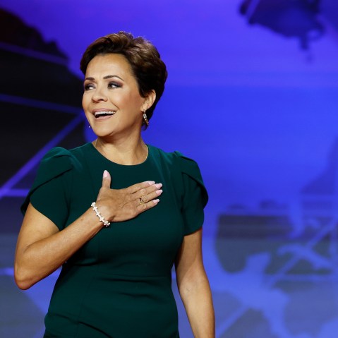 Kari Lake holds her hand on her chest.