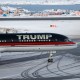 A plane with "TRUMP" written on the side sits on a snowy tarmac.