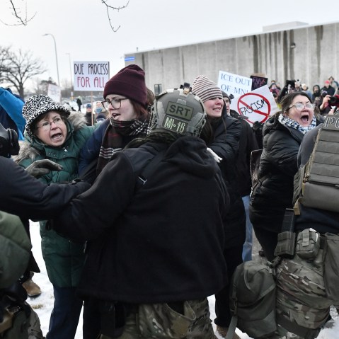 Protestors shout as they fight with federal agents.