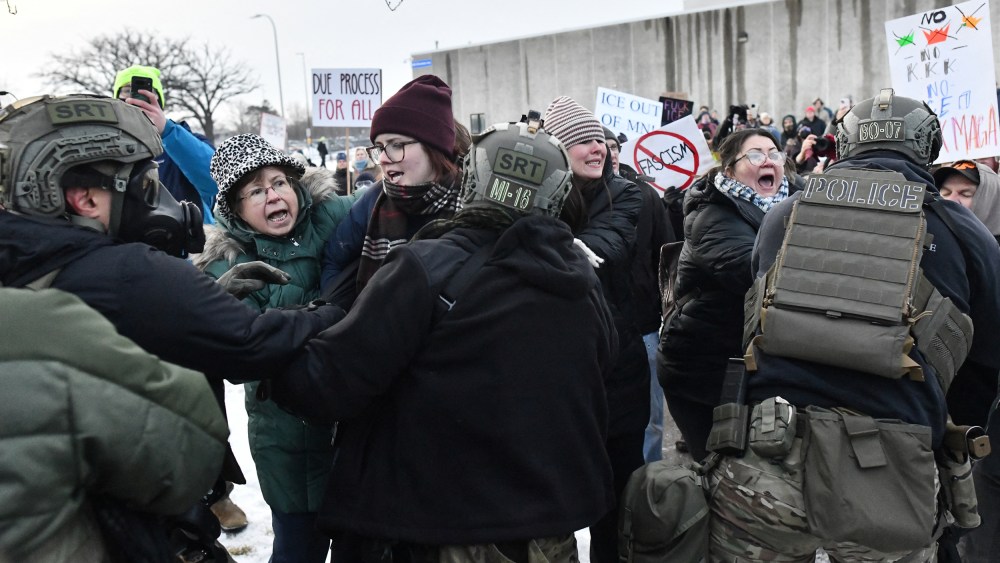 Protestors shout as they fight with federal agents.