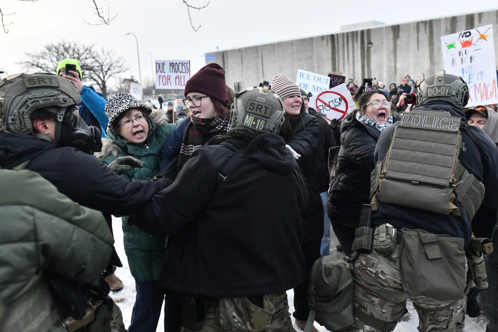 Protestors shout as they fight with federal agents.