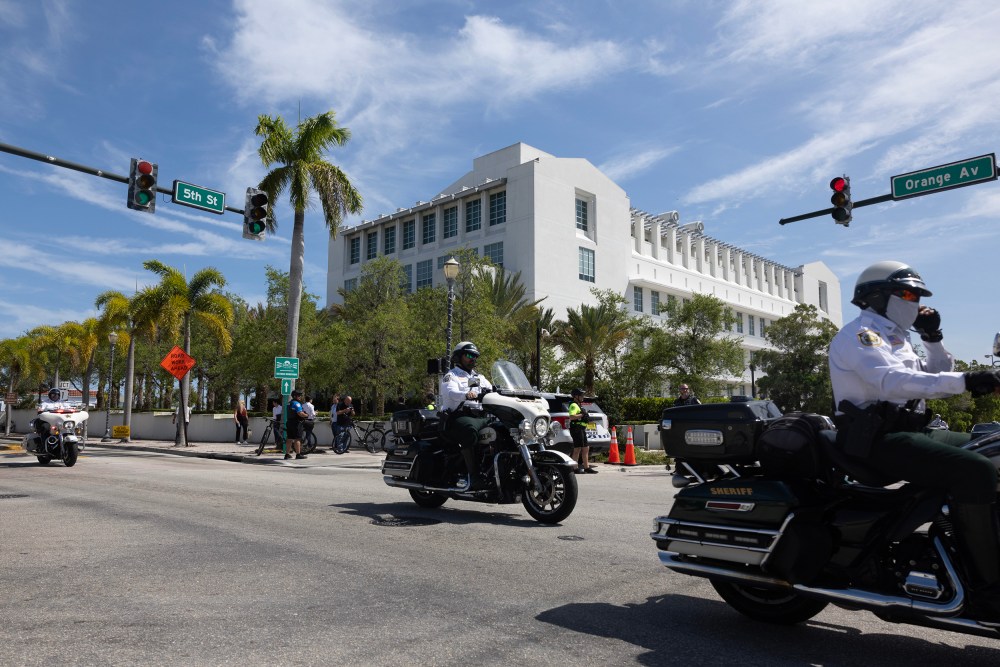 Officers drive past a white courthouse in Florida.