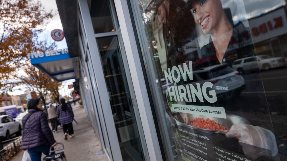 A “Now Hiring” sign is seen on a Chipotle window.