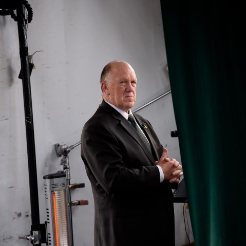 Border czar Tom Homan stands backstage, placed in the middle of the frame.