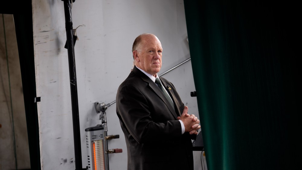 Border czar Tom Homan stands backstage, placed in the middle of the frame.