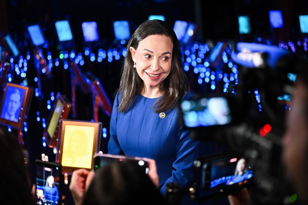 Maria Corina Machado stands in front of Peace Prize exhibition in Oslo.
