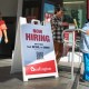 A 'Now Hiring' sign sits outside the entrance to a Burlington department store.