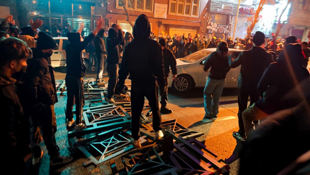 A big group of protestors stand on the street.