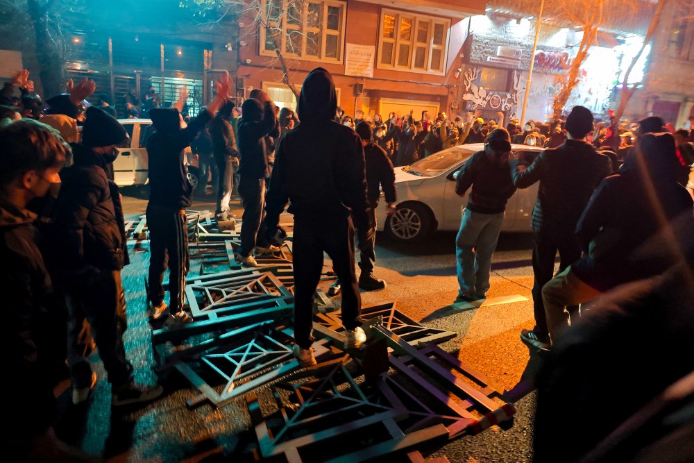 A big group of protestors stand on the street.