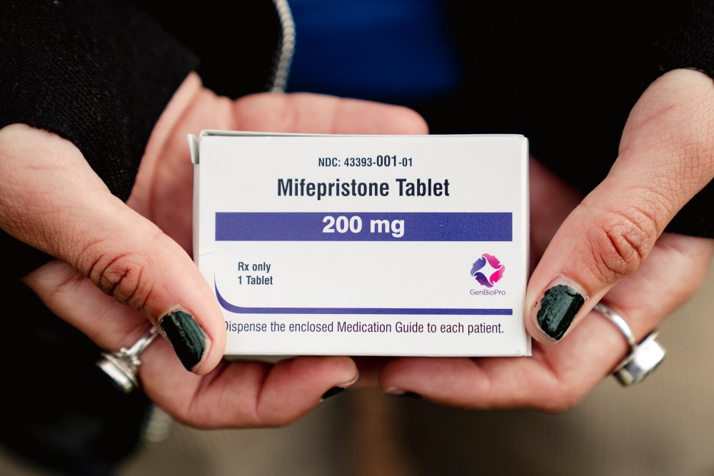Trans man and abortion rights advocate Artemis Duffy holds a box of mifepristone on March 26, 2024 outside the U.S. Supreme Court.