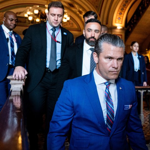 Pete Hegseth walks into the U.S. Capitol, followed by several other men.