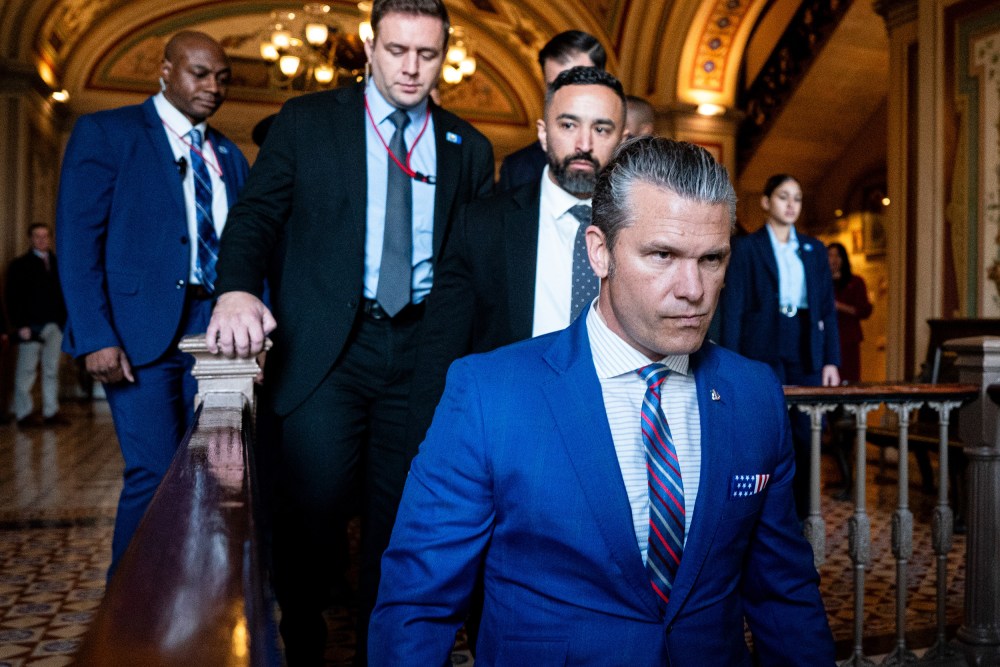 Pete Hegseth walks into the U.S. Capitol, followed by several other men.