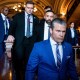 Pete Hegseth walks into the U.S. Capitol, followed by several other men.