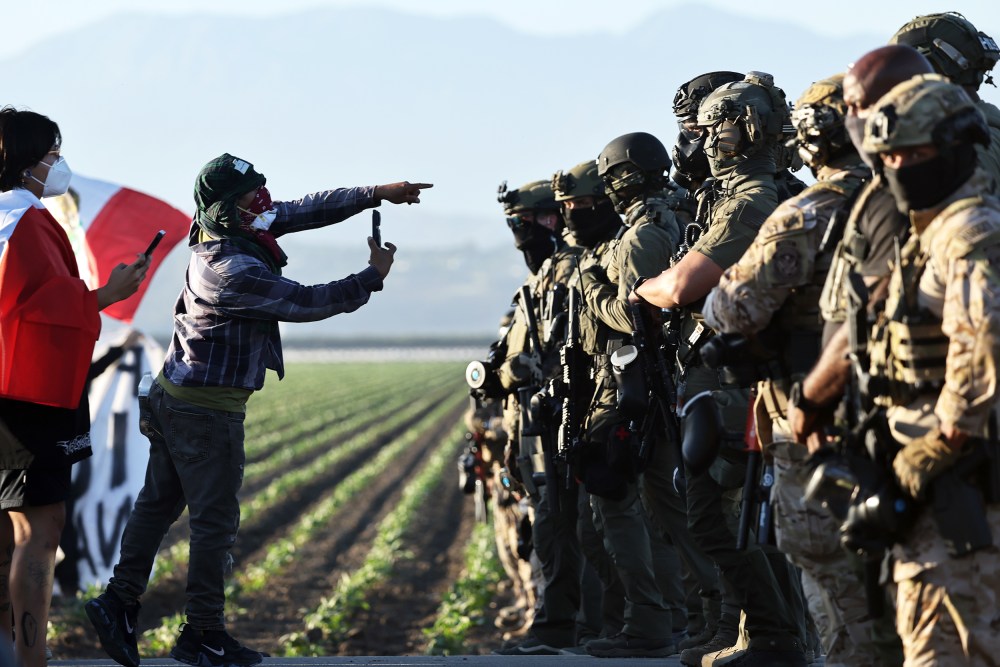 Federal agents block people protesting an ICE immigration raid on July 10, 2025 in Camarillo, CA.