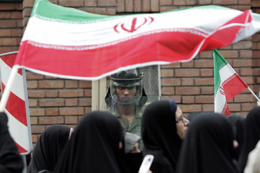 An Iranian riot policeman stands guard as demonstrators protest in Tehran.