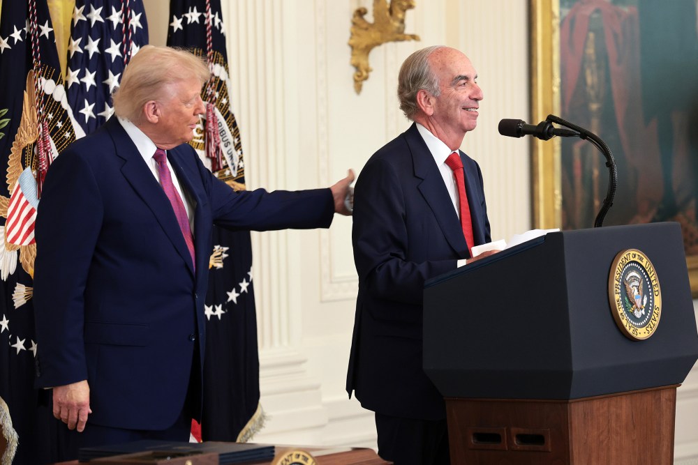 President Donald Trump pats the back of John Hess as he delivers remarks on June 12, 2025 in the East Room of the White House.