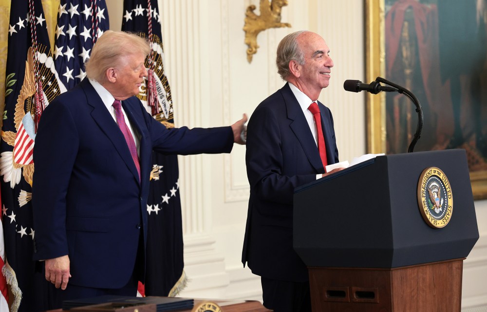 President Donald Trump pats the back of John Hess as he delivers remarks on June 12, 2025 in the East Room of the White House.
