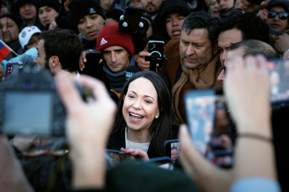 Mar&iacute;a Corina Machado surrounded by people with phones and cameras.