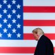 President Trump walks off stage. We see his profile in front an American flag backdrop.