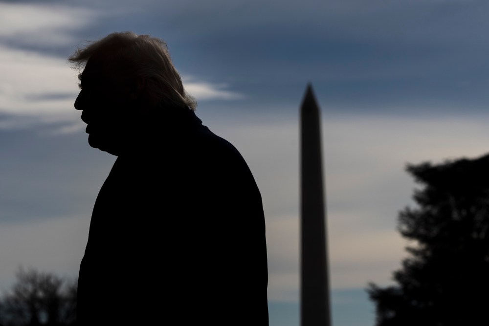 A silhouette of President Donald Trump on the South Lawn of the White House.