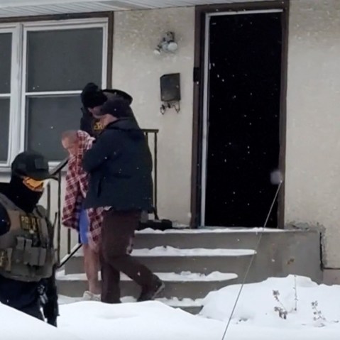 ICE agents walk ChongLy &ldquo;Scott&rdquo; Thao, an elderly Asian man, out of his home as he only wears shorts and crocs and a blanket covering draped over his shoulders.