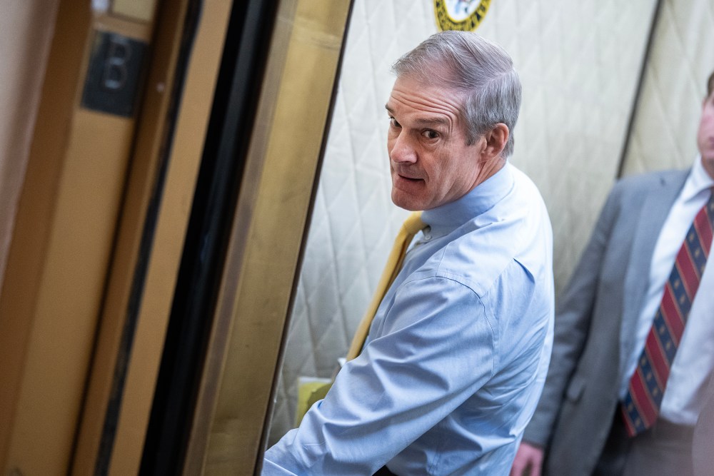 Rep. Jim Jordan pressing a button in the elevator while a young man stands behind him.