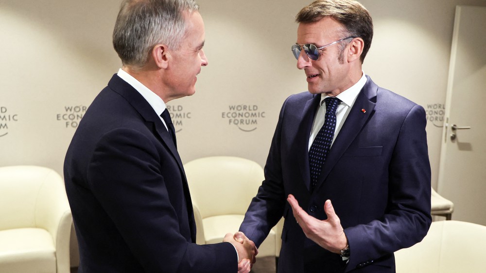 France's President Emmanuel Macron (right) shakes hands with Canada's Prime Minister Mark Carney at the World Economic Forum on Jan. 20, 2026, in Davos, Switzerland.