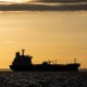 The silhouette of an oil tanker at sunrise.