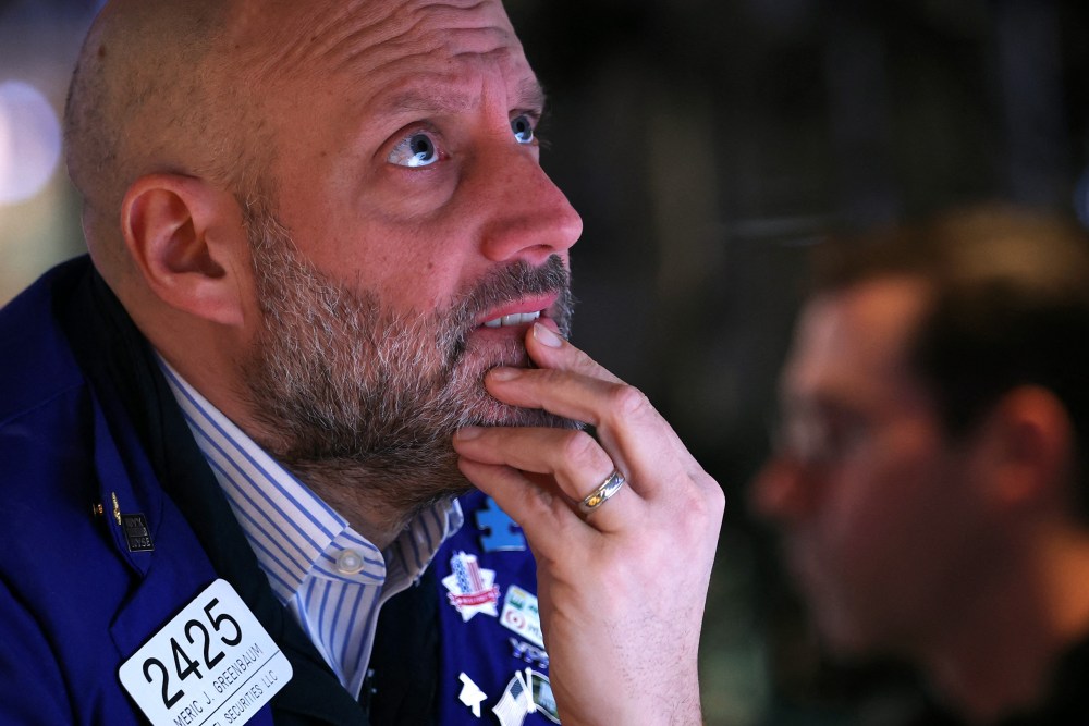 A trader with a concerned look on their face and their hand on their chin.