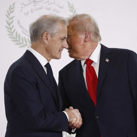 Jonas Gahr Store, left, is shaking Donald Trump's hand with Trump's face behind Store's.